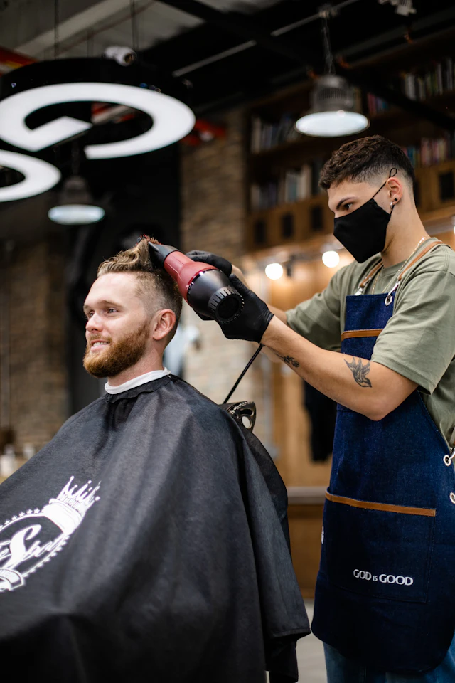 Barbeiro secando o cabelo do cliente