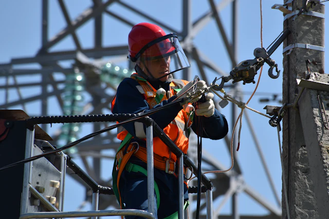 Técnico de capacete vermelho trabalhando em cesto aéreo na rede elétrica