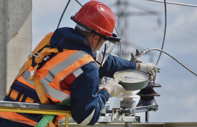 Técnico com equipamento de segurança fazendo manutenção em isoladores