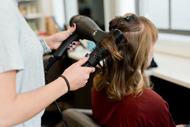 Cabeleireira secando o cabelo da cliente