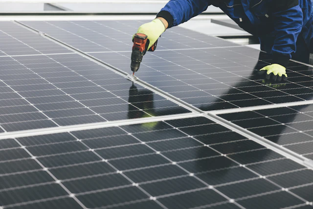 Instalador parafusando um painel solar com parafusadeira