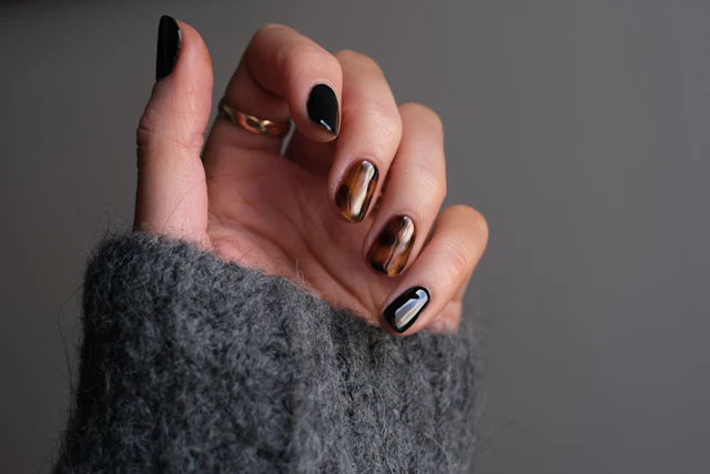 Mão com anel e unhas pretas